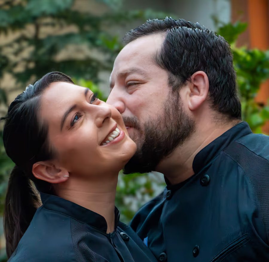 Colon kissing Britt on the cheek as she smiles